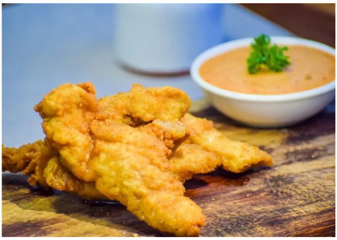 Golden chicken strips with a dipping sauce